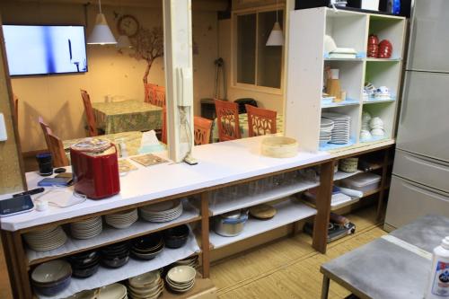 a room with a table with plates and bowls at Minpakushisetsu Nipopo - Vacation STAY 19569 in Fukagawa