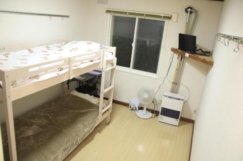 a small room with a bunk bed and a window at Minpakushisetsu Nipopo - Vacation STAY 19569 in Fukagawa