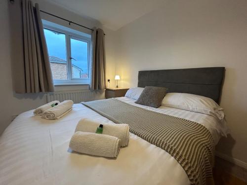 a bedroom with a large bed with two towels on it at 3 Bedroom, Parking, 2 Toilets, Wi-Fi, Modern in Crewe