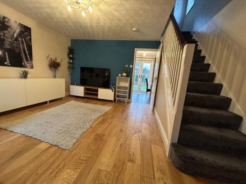 a living room with a staircase and a television at 3 Bedroom, Parking, 2 Toilets, Wi-Fi, Modern in Crewe