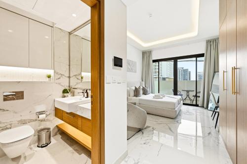 Un baño blanco con inodoro y lavabo. en Riviera Azure Gateway Superior- 10min to Burj Khalifa, Dubai Mall and Airport and 20min to Marina, en Dubái
