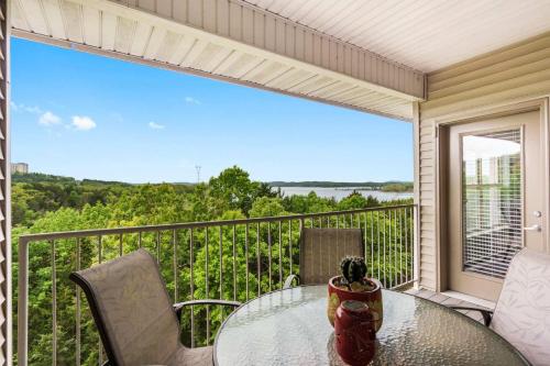 a table and chairs on a balcony with a view at Sunset Daydream - Elegant Condo on Table Rock in Branson