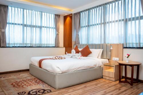 ein Schlafzimmer mit einem großen Bett und großen Fenstern in der Unterkunft Hotel Badrinath in Kathmandu