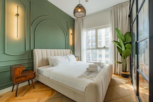 a bedroom with a white bed and a green wall at Elite Escapes - Socio Stylish 1 BHK Getaway in Dubai