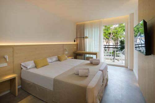 a bedroom with a large bed and a large window at Cabot Cala Ferrera in Cala d´Or