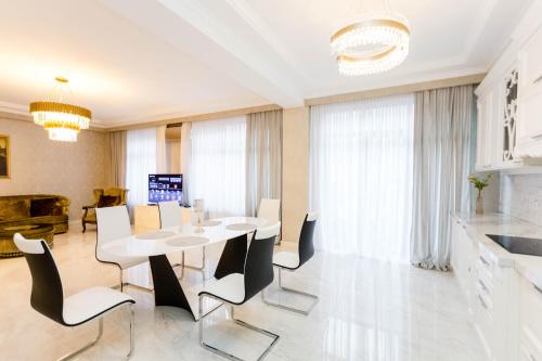 a dining room with a white table and chairs at Central Elegant Apartment in Tbilisi City