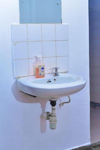 a white sink in a white tiled bathroom at Eldo oasis in Eldoret