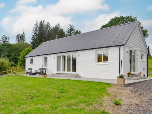 a white cottage with a black roof at Boatman's Cottage At Invernian Mor in Inverinan Beg