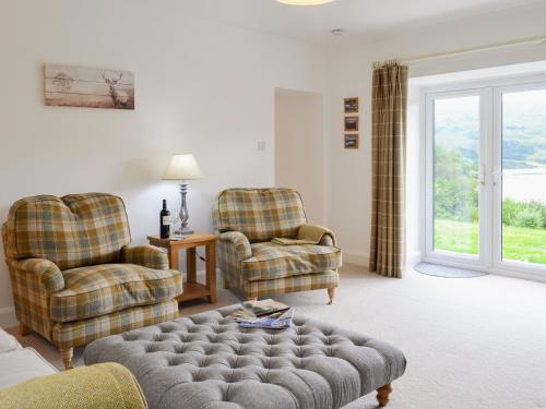 a living room with two chairs and a couch at Boatman's Cottage At Invernian Mor in Inverinan Beg