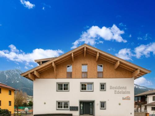 a white building with a wooden roof at Luxury penthouse with Balcony, Ski Storage, Carport, Lift in Brixen im Thale