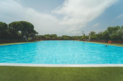 a large swimming pool with blue water at Tres Estrellas Barcelona by HolaCamp in Gavà