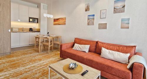 un salon avec un canapé et une table dans l'établissement HolidayHomePL Bel Mare F540 z balkonem, à Międzyzdroje