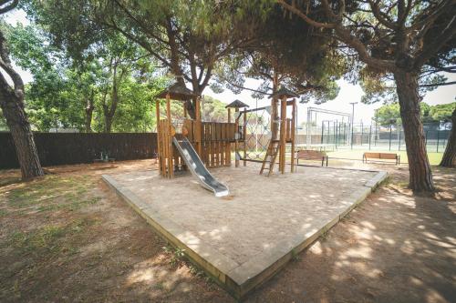 a playground with a slide in a park at Tres Estrellas Barcelona by HolaCamp in Gavà