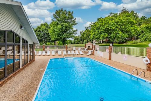 a swimming pool with lounge chairs next to a house at Great Escape Duo in Branson