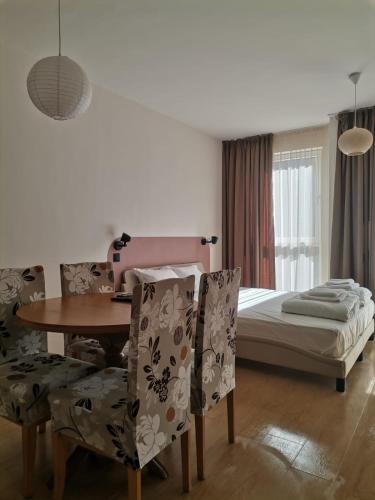 a bedroom with a table and chairs and a bed at Студио 8 Уютна Почивка in Hisarya