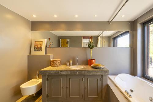 une salle de bain avec une baignoire et un lavabo et une baignoire dans l'établissement Carmim Villa by Cadenzalux, à Biscaia