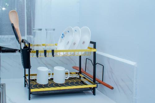 a plate rack with plates and mugs on it at Lake View Suites, Homa Bay in Homa Bay