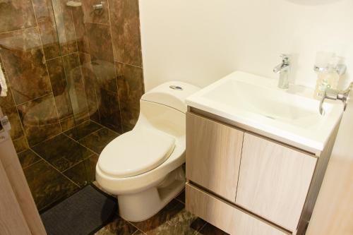 a bathroom with a toilet and a sink and a shower at Frente a Viva Envigado, AC, moderno e iluminado in Envigado