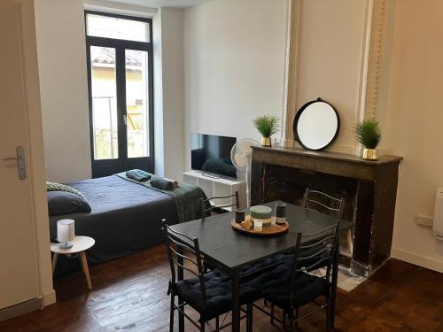 a bedroom with a bed and a table with a mirror at Apparemment rénové- 2 appartements au choix in Bourg-de-Péage