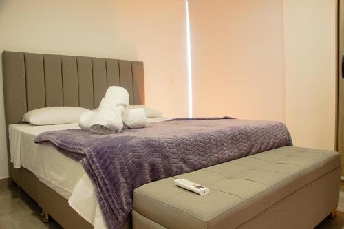 a bedroom with a bed with a remote control on it at Frente a Viva Envigado, AC, moderno e iluminado in Envigado