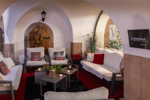 圣伊波利特Hôtel Val-Vignes Colmar Haut-Koenigsbourg, The Originals Relais的配有白色沙发和桌子的客厅