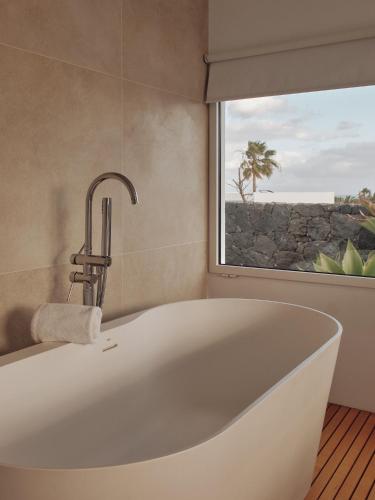 a white bath tub in a bathroom with a window at Villas Elements by Alondra in Puerto del Carmen