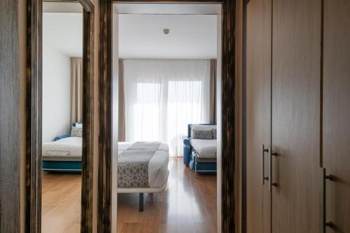 a bedroom with two beds and a mirror at Park Hotel San Jorge & Spa by Escampa Hotels in Platja  d'Aro
