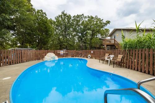 a blue swimming pool in front of a wooden fence at Enchanted Woods Retreat-Decorated for Christmas in Branson
