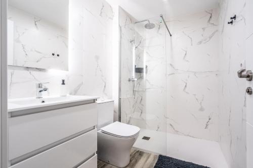 a white bathroom with a toilet and a sink at Duplex-Port-Valencia 14 in Valencia