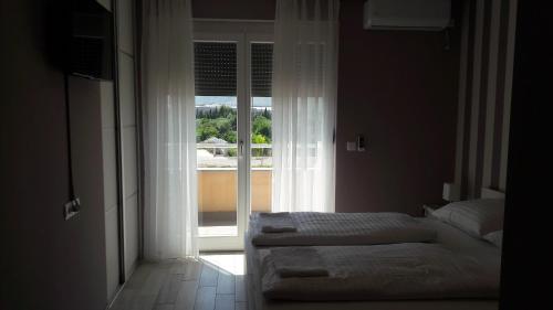 a bedroom with two beds in front of a window at Sun Apartments in Mostar