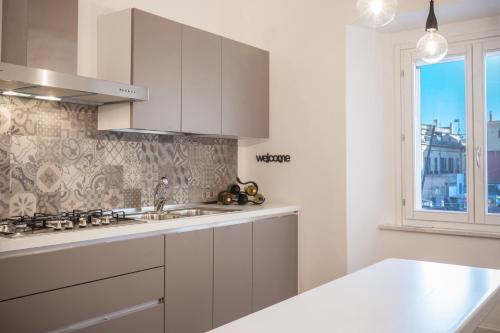 a white kitchen with a sink and a window at Arcipelago 41 in Cagliari