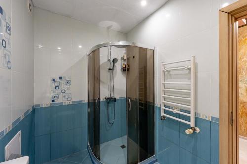 eine Dusche im Bad mit blauen und weißen Fliesen in der Unterkunft Beni Deluxe 1 in Plowdiw