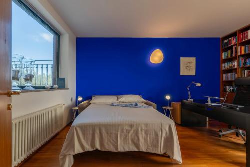 ein Schlafzimmer mit einer blauen Wand, einem Bett und einem Schreibtisch in der Unterkunft VILLA AMYRA 6&2, Emma Villas in Madonna della Pace