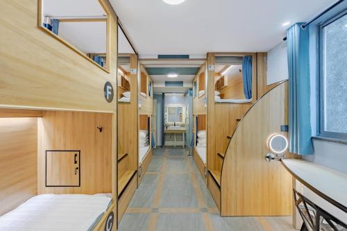 Habitación pequeña con paredes de madera y literas. en Kunlun International Youth Hostel, en Huangshan Scenic Area