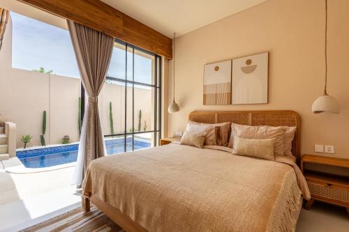 a bedroom with a bed and a large window at Pasir 2 - A stylish 2 bed villa in Bingin w pool in Bingin Beach