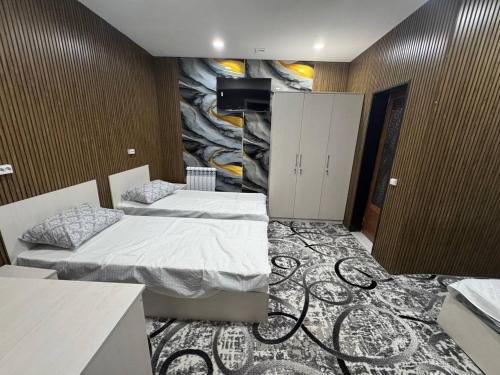 a room with two beds and a painting on the wall at Amiriy hostel in Bukhara