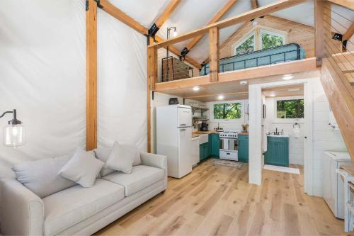 a living room with a couch and a kitchen at Cedar Creek - Glamping in the Ozarks in Walnut Shade