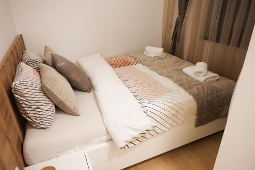 a bed with pillows on it in a room at Bjelasnica Bliss Apartment in Bjelašnica