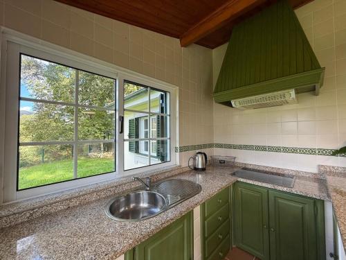 een keuken met een spoelbak en een raam bij Sobreiros' Studio - Gerês in Terras de Bouro