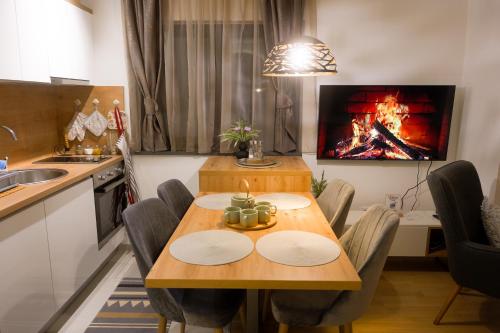 a kitchen with a table with chairs and a fireplace at Bjelasnica Bliss Apartment in Bjelašnica