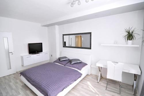 a bedroom with a bed and a table and a mirror at AVAX apartment Liberec in Liberec
