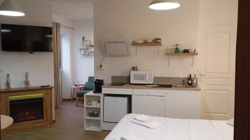 uma pequena cozinha com fogão e micro-ondas em Le cocon des Rosies le Eleanor Roosevelt em Colleville-sur-Mer