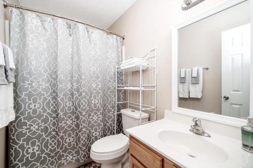 a bathroom with a shower with a toilet and a sink at 3BR Home with Smart TVs in Every Room, King Suite & Pool Table in New Bern
