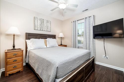 a bedroom with a bed and a flat screen tv at 3BR Home with Smart TVs in Every Room, King Suite & Pool Table in New Bern