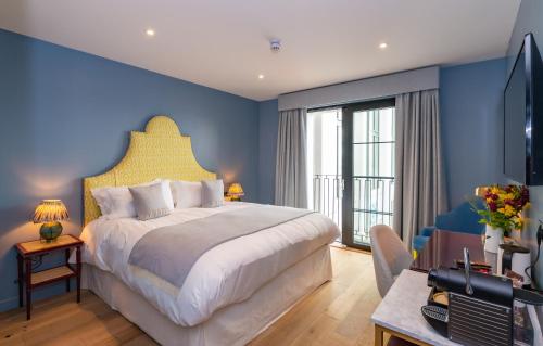 ザ・マンブルズにあるOyster Houseの青い壁の大きなベッドのある寝室