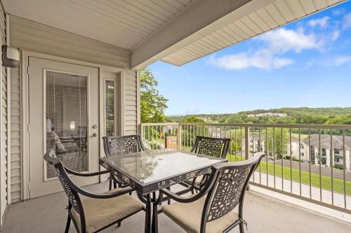 a patio with a table and chairs on a balcony at Golf Course View at the Foothills Resort in Branson