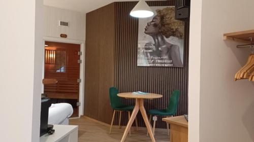 um quarto com uma mesa e duas cadeiras verdes em Le cocon des Rosies le Eleanor Roosevelt em Colleville-sur-Mer