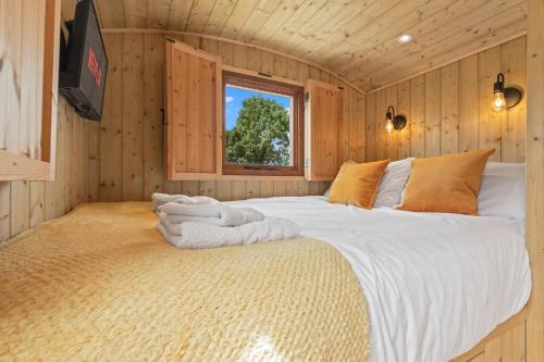 YarpoleにあるOff-Grid Glamping - Quiet, Starry Escapeの木製の部屋に大型ベッドが備わるベッドルーム1室が備わります。