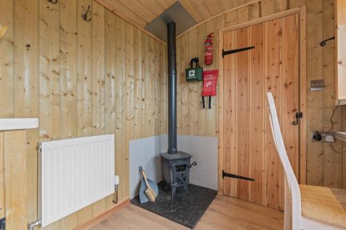 YarpoleにあるOff-Grid Glamping - Quiet, Starry Escapeのキャビン内の薪ストーブ付きの部屋