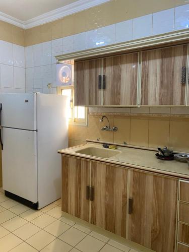een keuken met een witte koelkast en een spoelbak bij فندق روز بلازا in Abha
